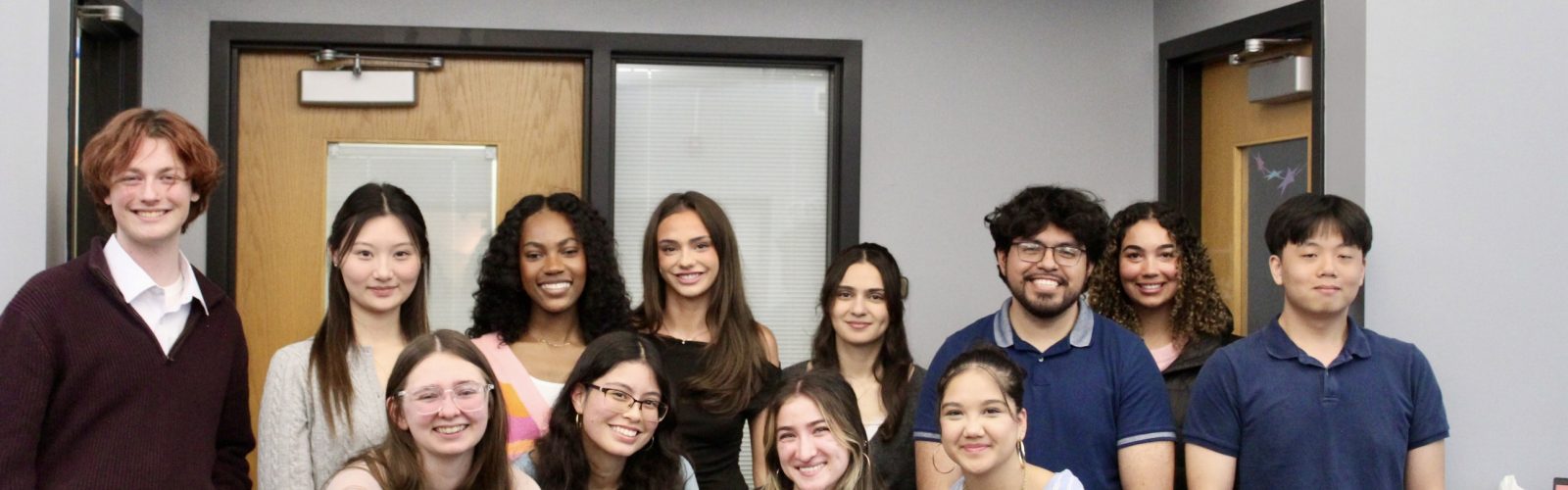 12 undergraduate student interns posing for a picture, smiling after presenting at their OEL Internship Showcase.